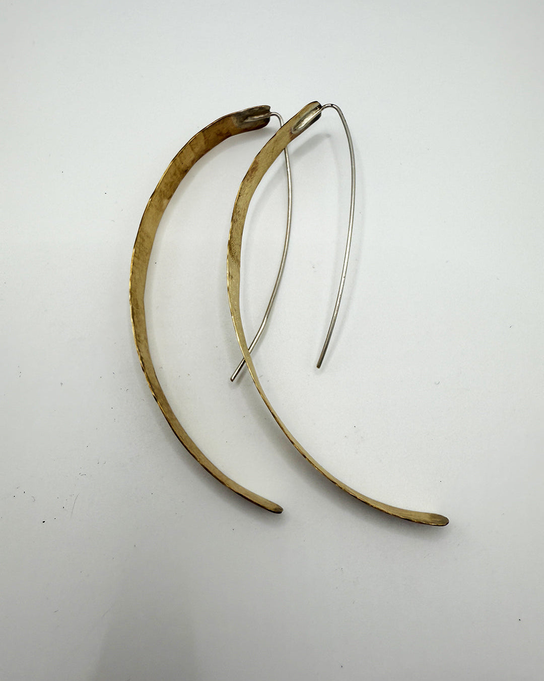 Pair of gold and silver hoop earrings on a white background