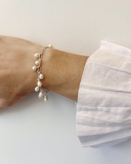 Pearl bracelet on a wrist with a white background