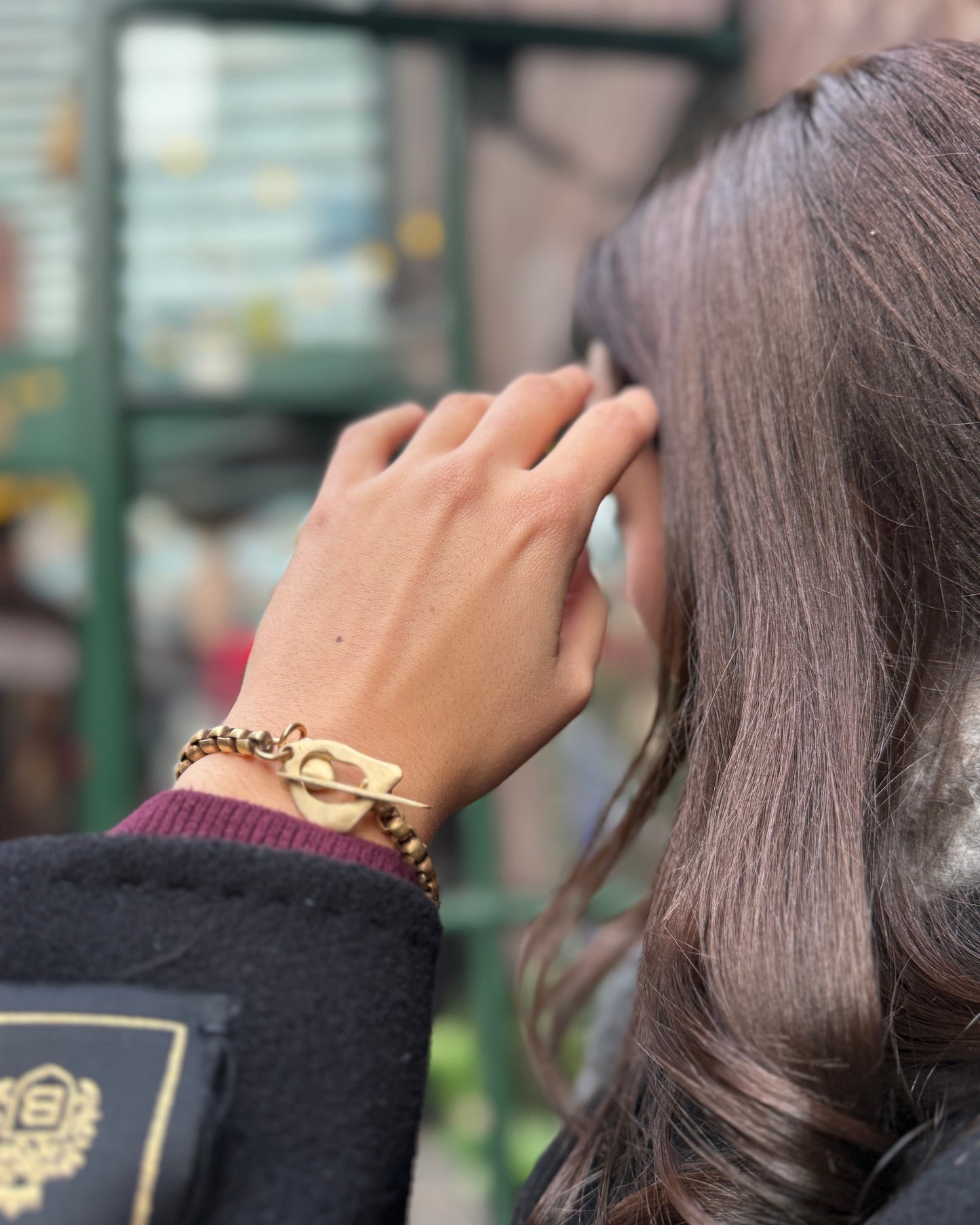 Person wearing a gold bracelet with a blurred background