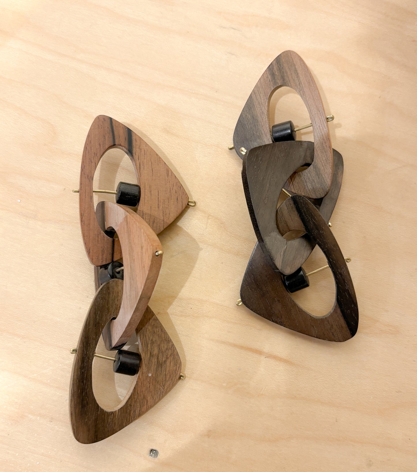 Pair or wooden geometric earrings on a  wooden surface