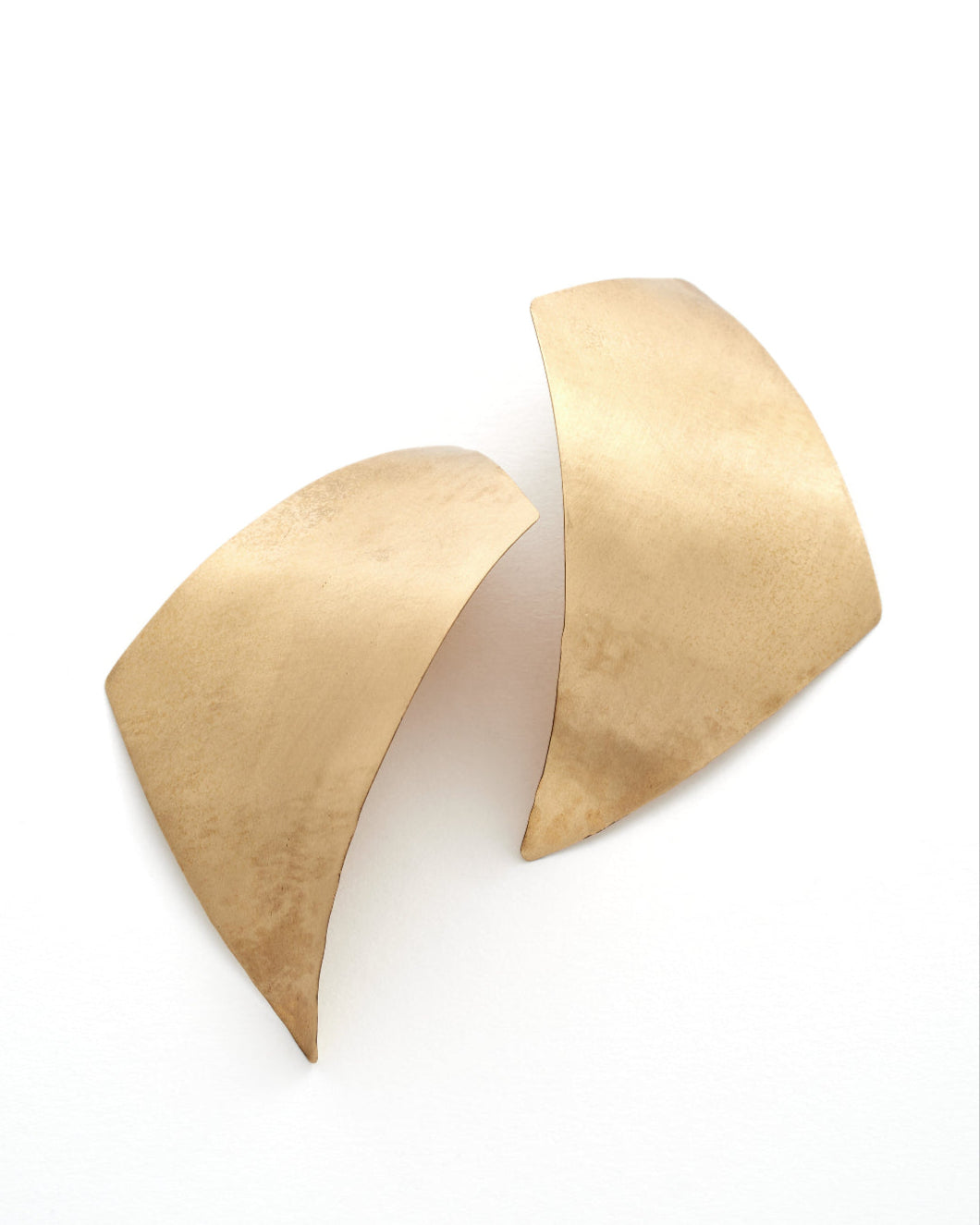 Curved bronze earrings on a white background