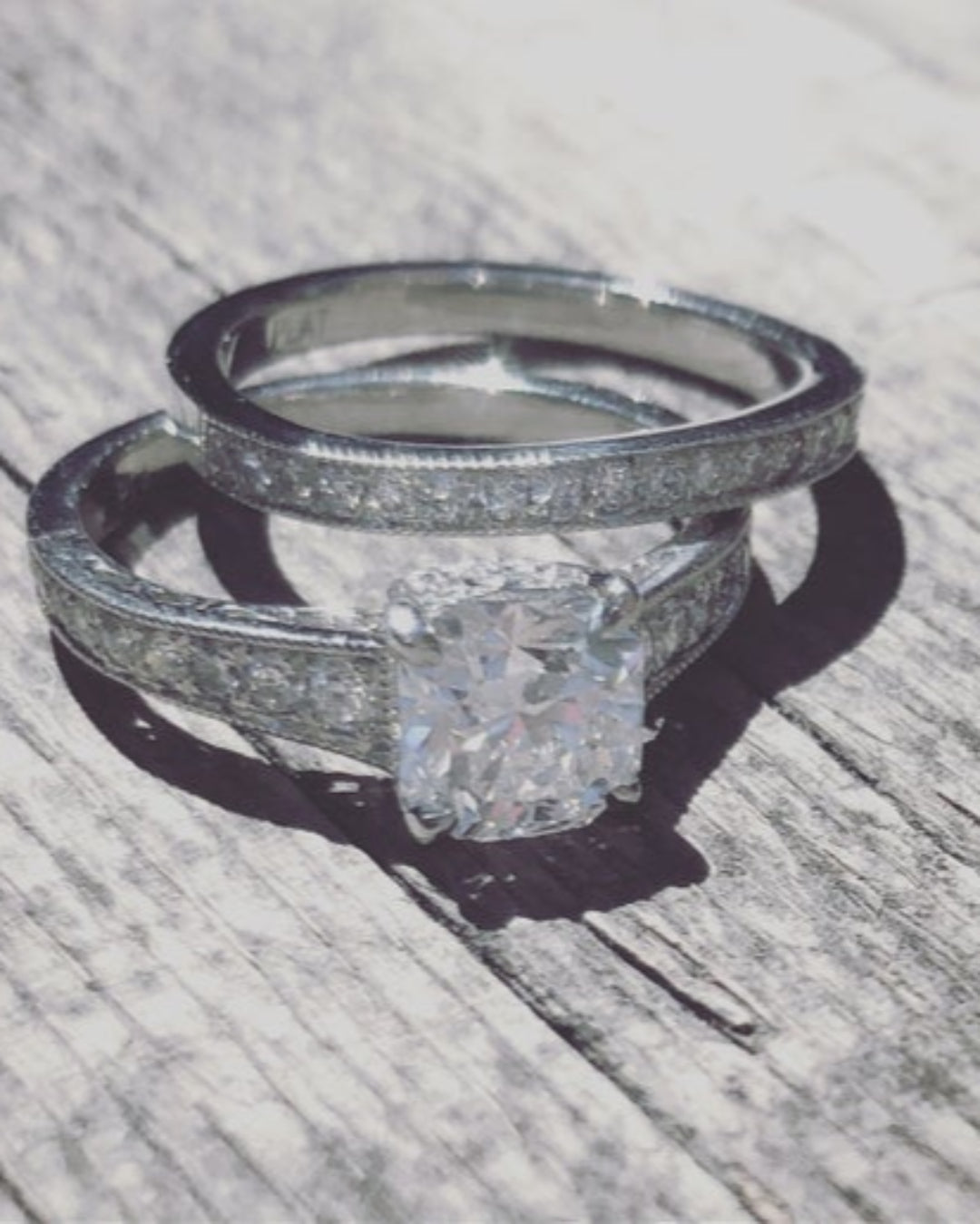 Silver diamond band and silver ring with a diamond band and a large diamond on a wooden surface