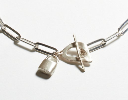 Silver paperclip necklace with a padlock charm on a white background