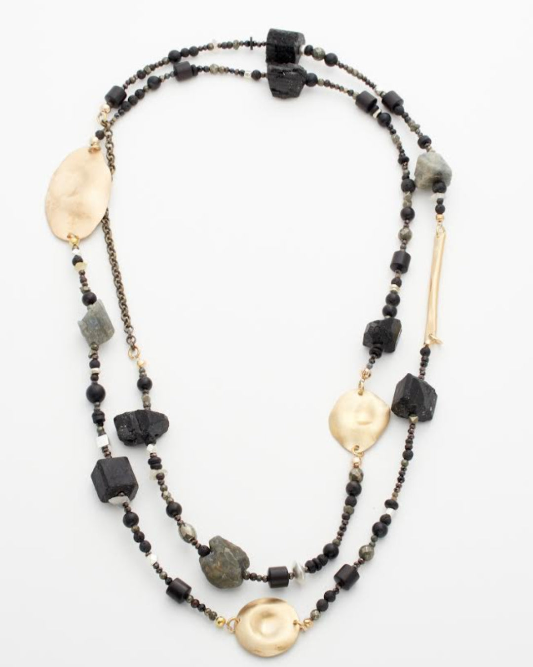 Long beaded necklace with gold and black beads on a white background