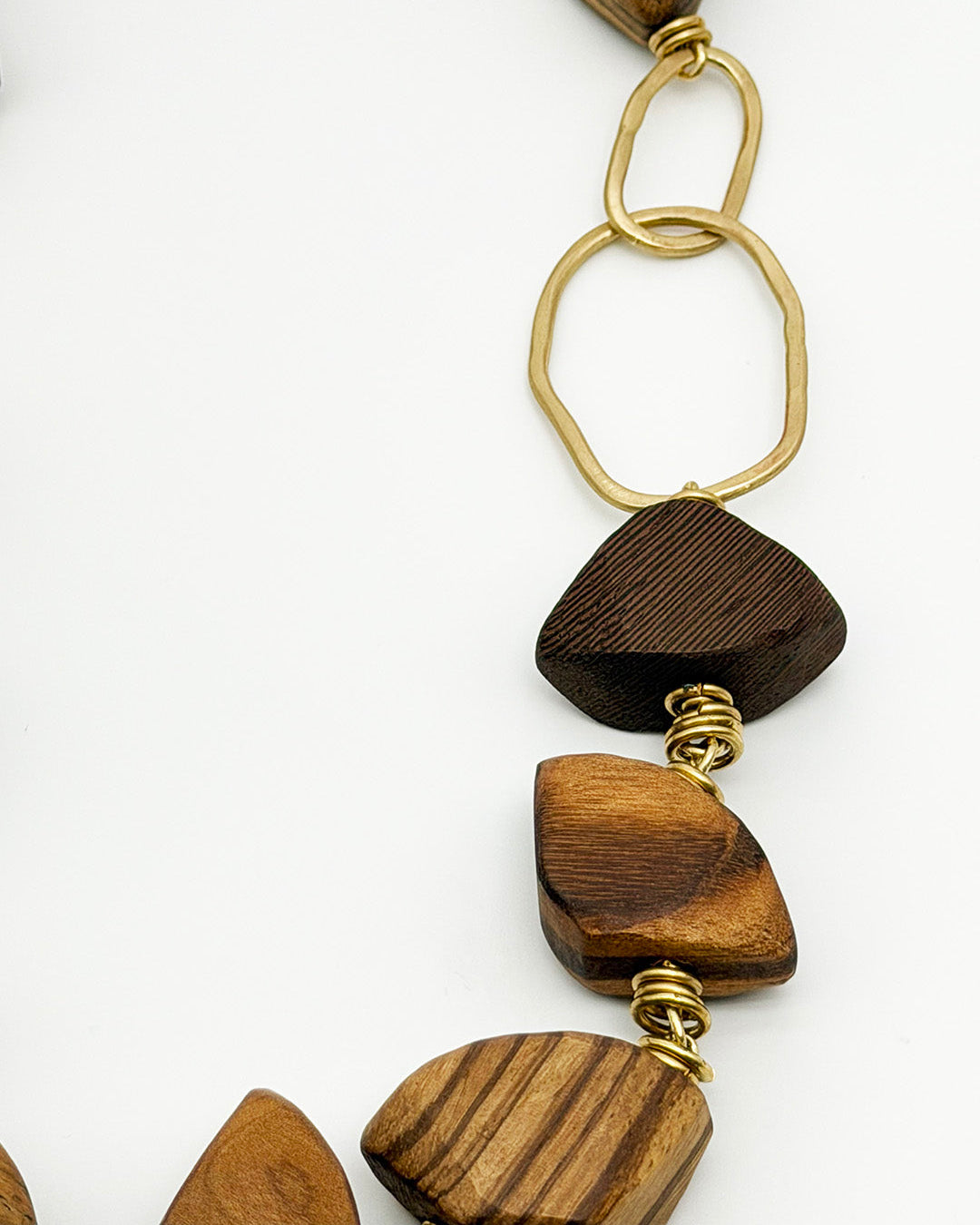 Wooden pendant necklace with gold accents on a white background