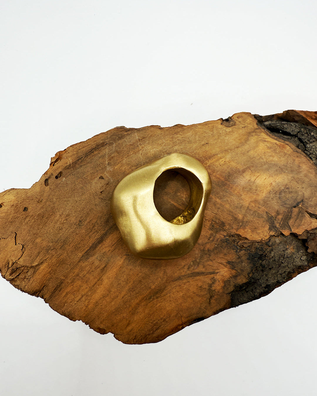 Gold ring on a wooden surface with a white background