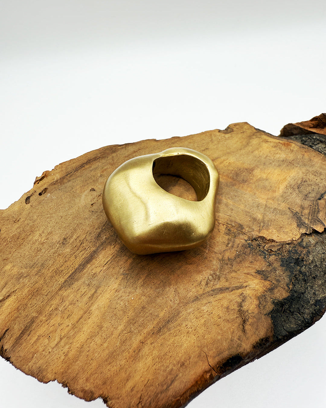 Gold ring on a wooden surface with a white background