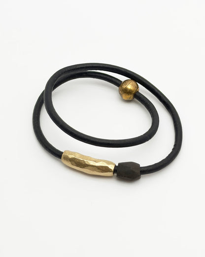 Black leather cord with gold metal clasps on a white background