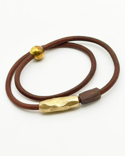 Brown leather cord with gold metal clasps on a white background