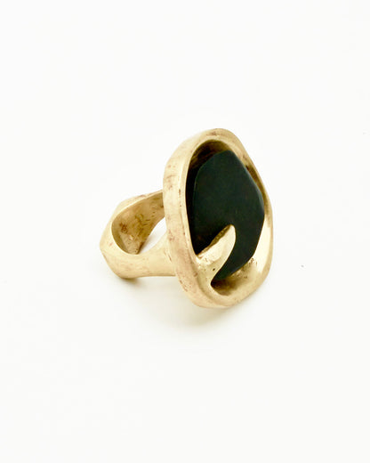 Gold ring with a black stone on a white background