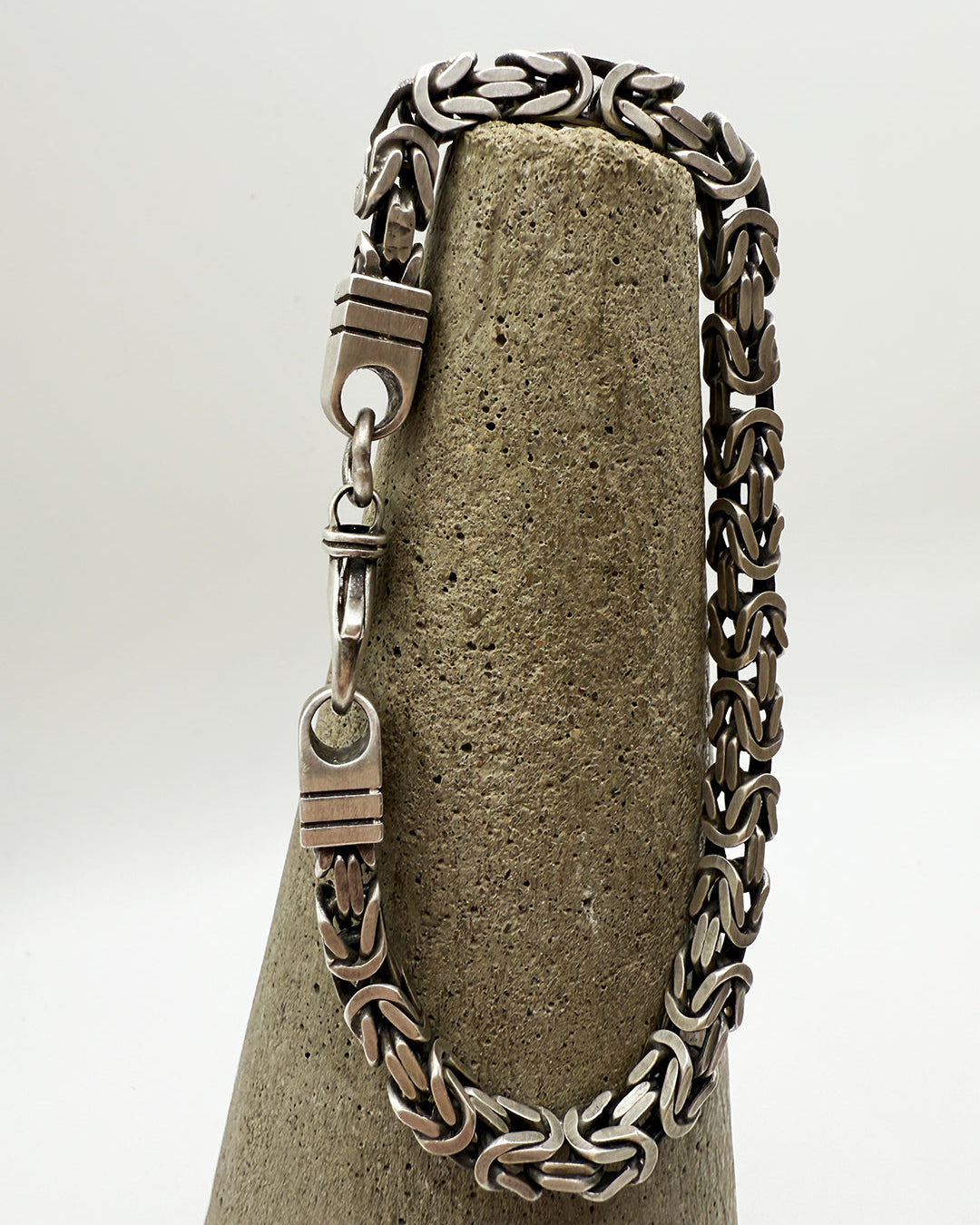Silver chain bracelet on a textured stone surface