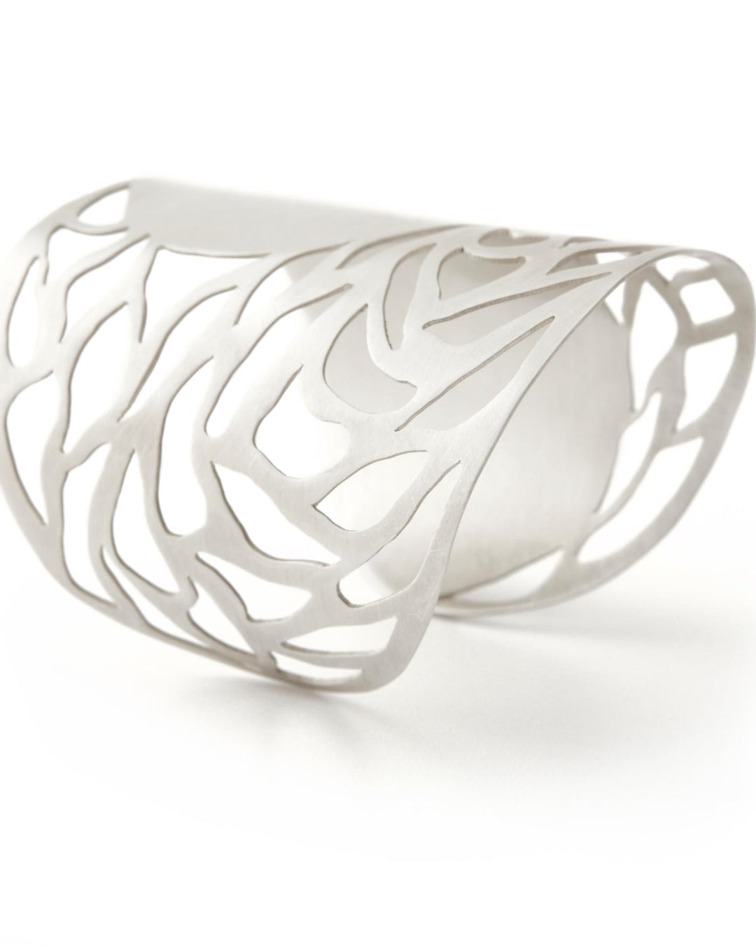 Silver cuff with intricate design on a white background