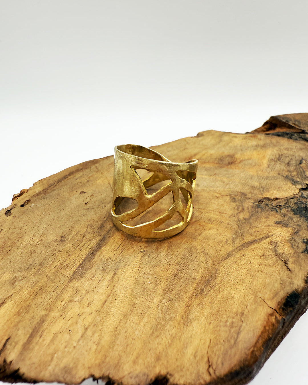 Gold ring on a wooden surface with a white background