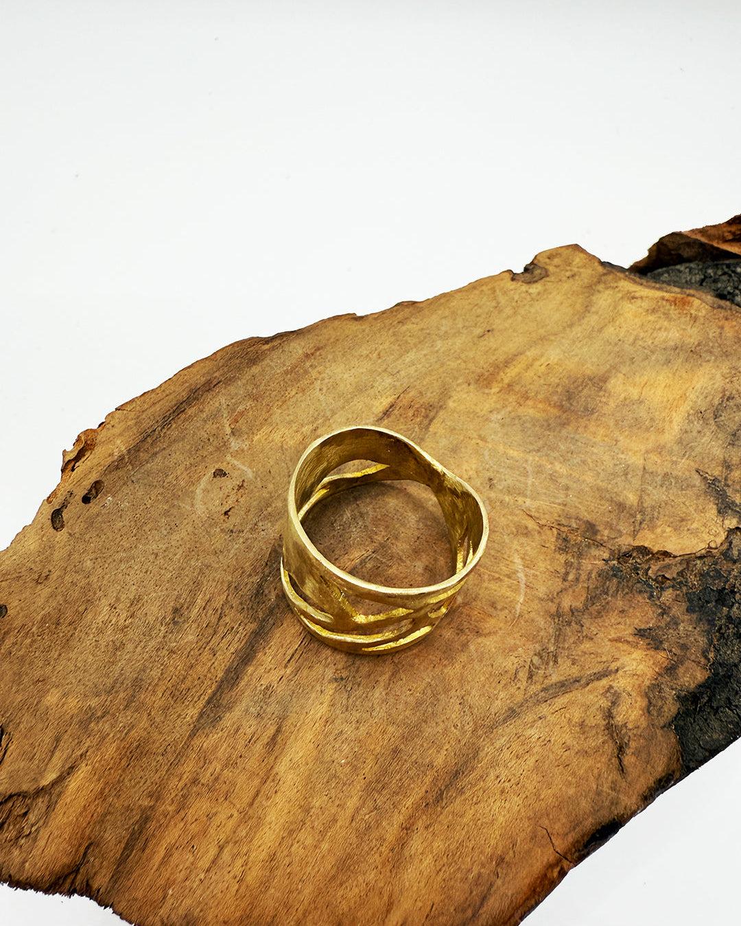 Gold ring on a wooden surface with a white background
