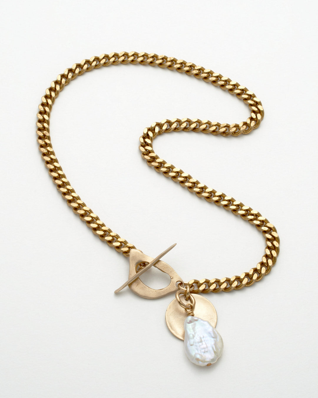 Gold chain necklace with a toggle clasp and teardrop-shaped pendant on a white background