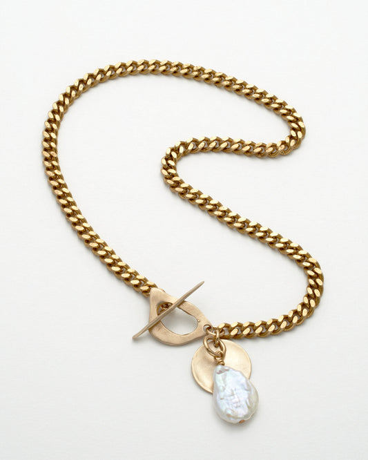 Gold chain necklace with a toggle clasp and teardrop-shaped pendant on a white background