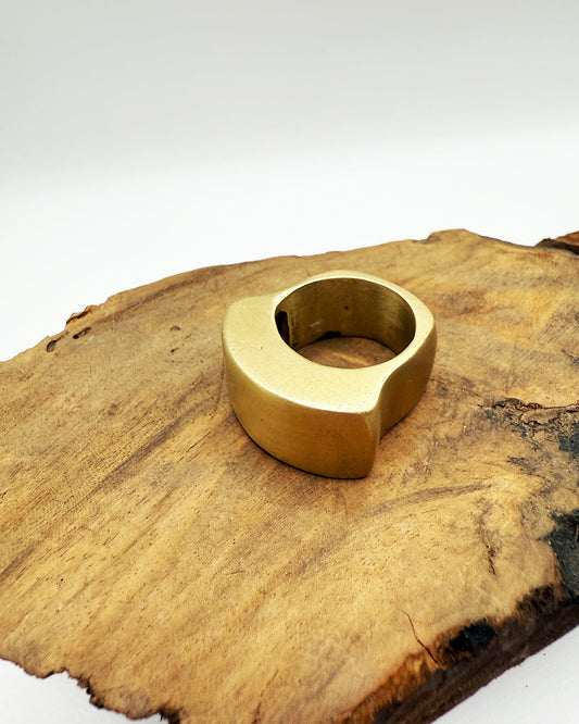 Gold ring on a wooden surface with a white background