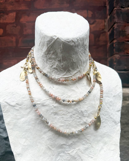 Necklace on a mannequin head with a brick wall background