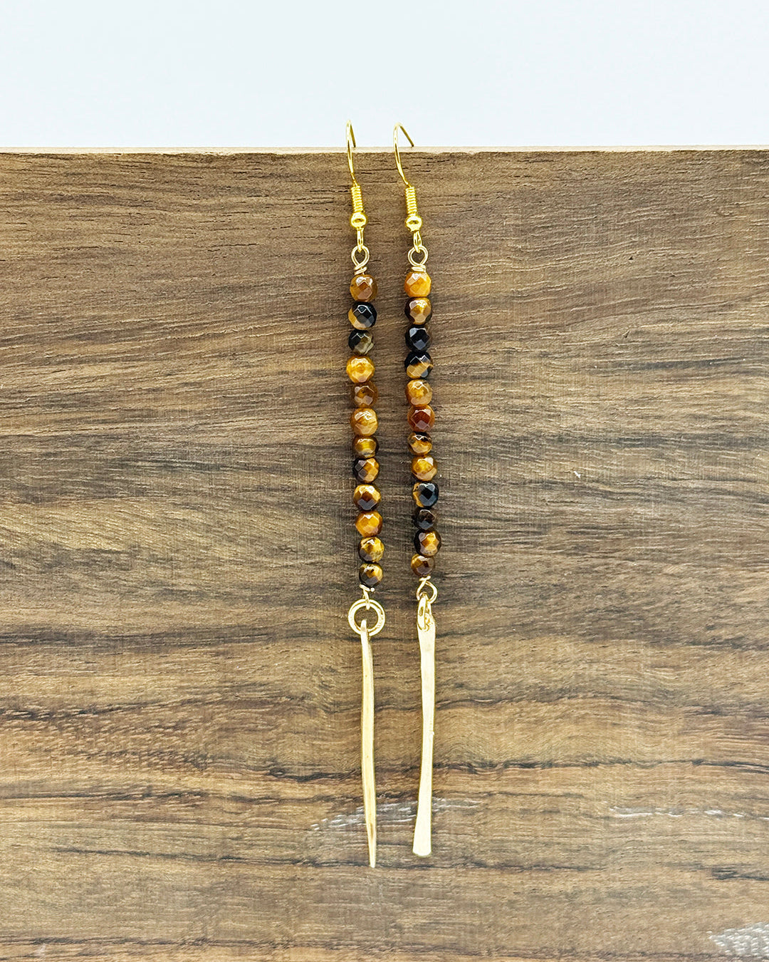 Beaded earrings on a wooden surface