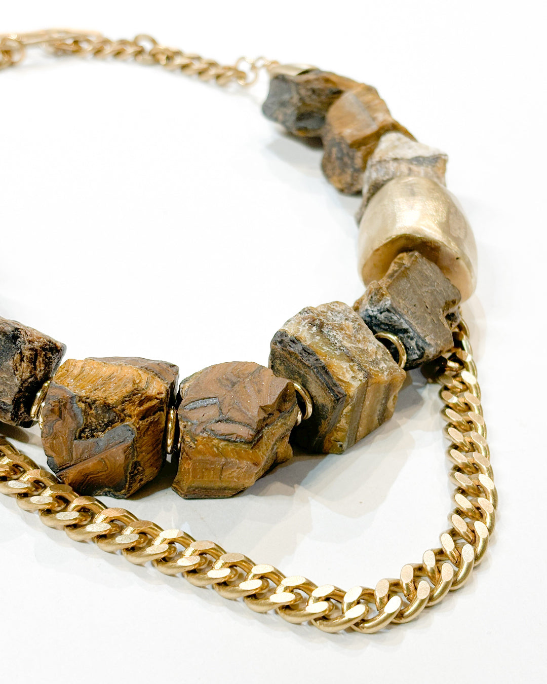 Necklace with gold chain and large brown beads on a white background