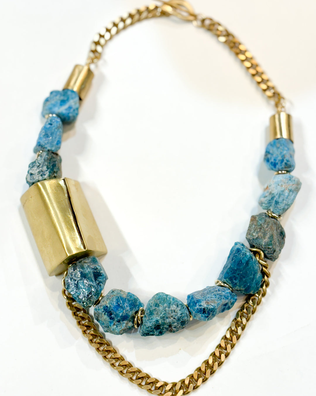 Necklace with blue beads and gold chain on a white background