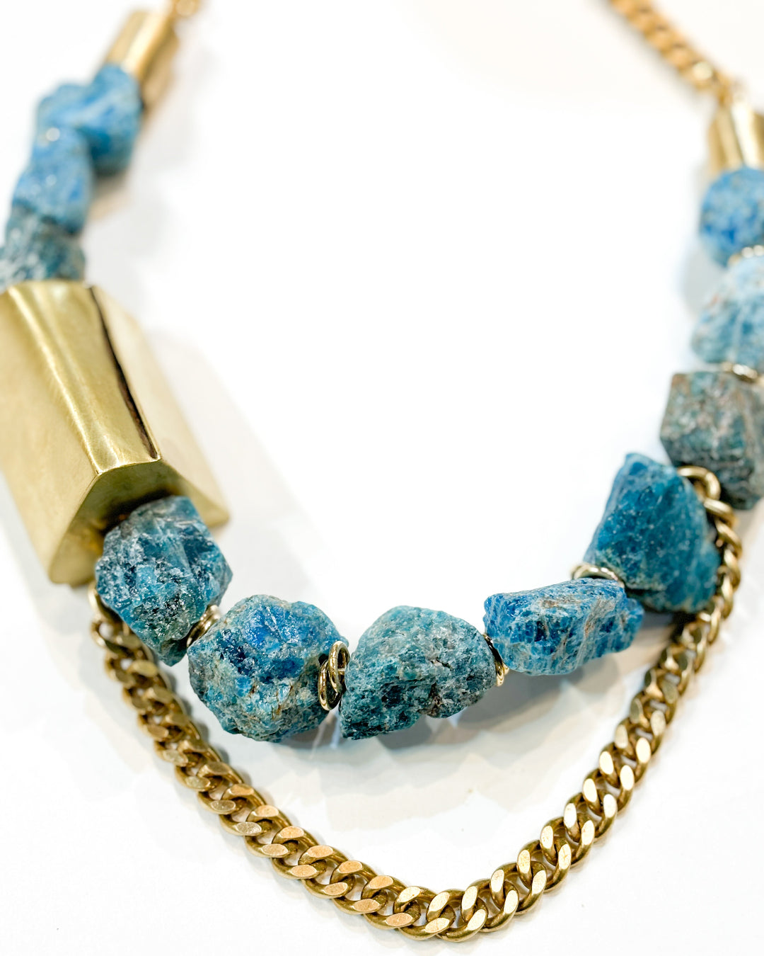 Necklace with blue beads and gold chain on a white background