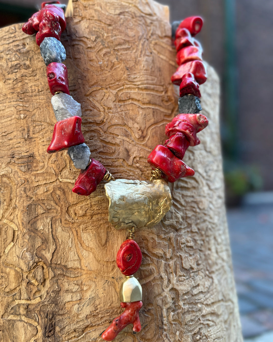 Necklace with red and bronze beads on a wooden surface