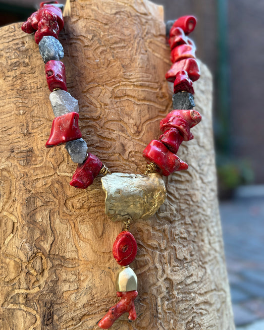 Necklace with red and bronze beads on a wooden surface