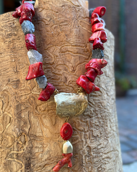 Necklace with red and bronze beads on a wooden surface
