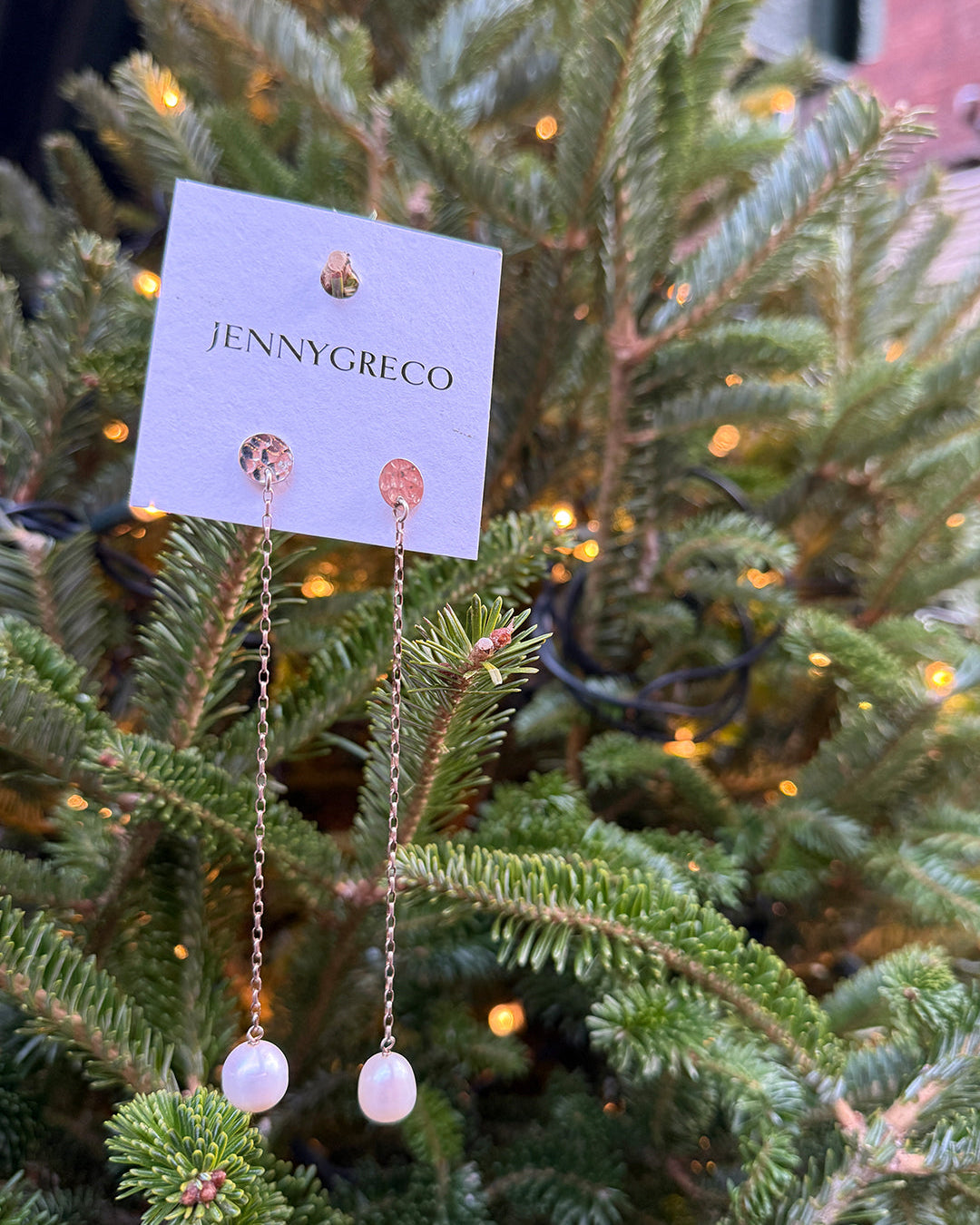 Pearl drop earrings on a Jenny Greco card suspended from a Christmas tree