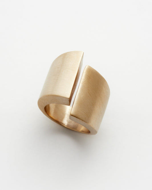 Gold ring with a geometric design on a white background