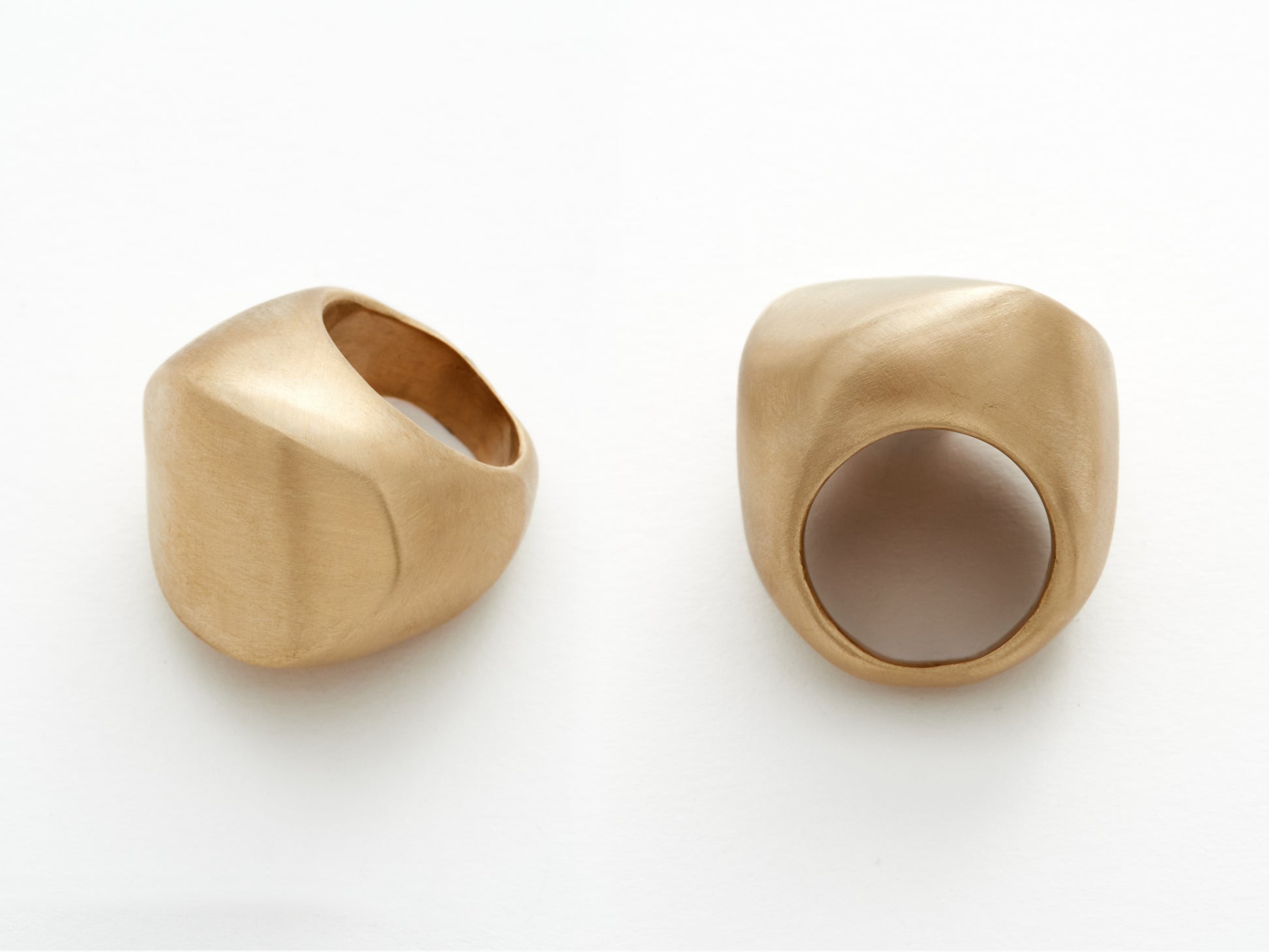 Two statement bronze rings with a textured surface on a white background