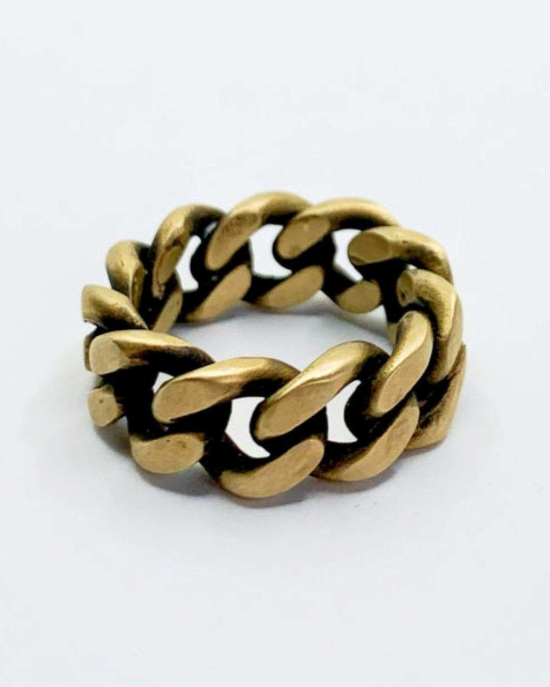 Gold chain-style ring on a white background