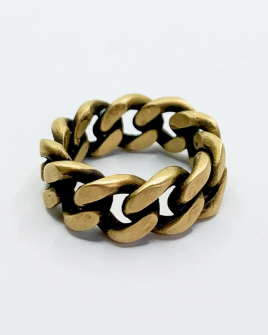Gold chain-style ring on a white background