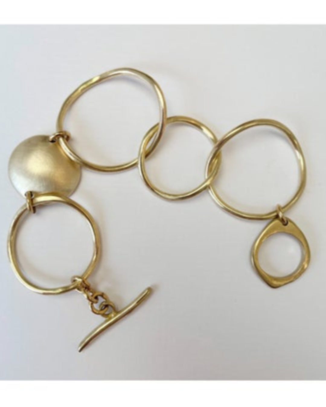 Gold bracelet with interlocking rings on a white background