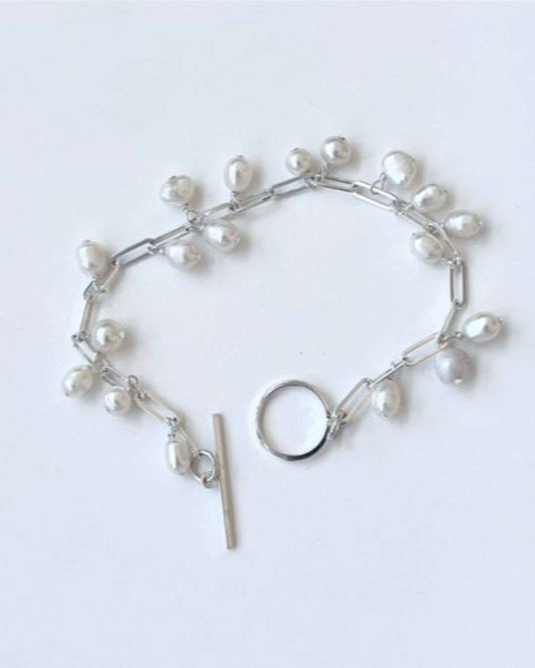 Silver bracelet with pearls on a white background
