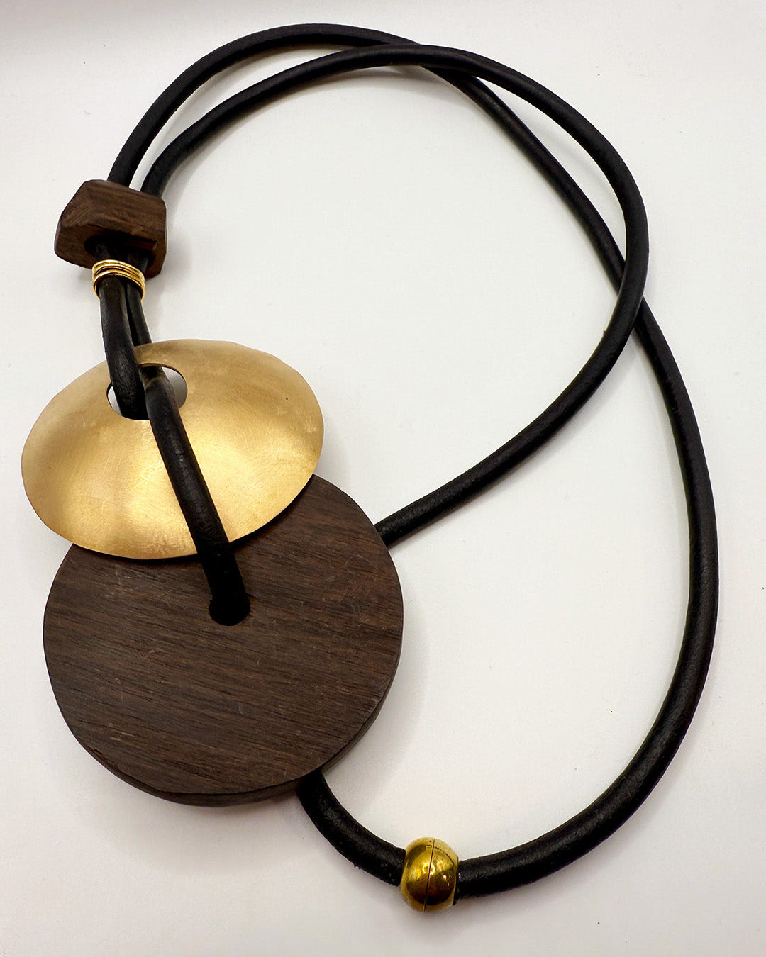 Necklace with wooden and brass pendants on a white background