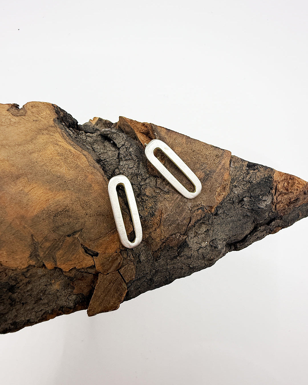 Fossilized arrowhead with two white oval stones on a white background