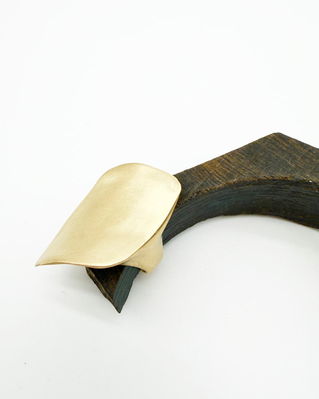Brass and black decorative item on a white background