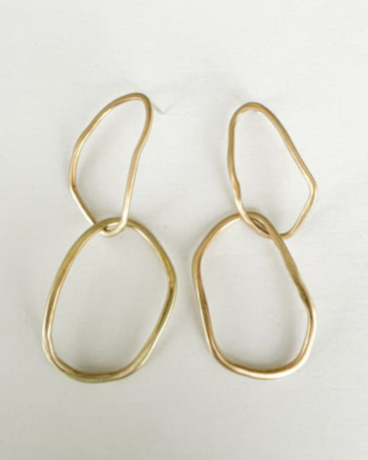 Gold double hoop earrings on a light gray background