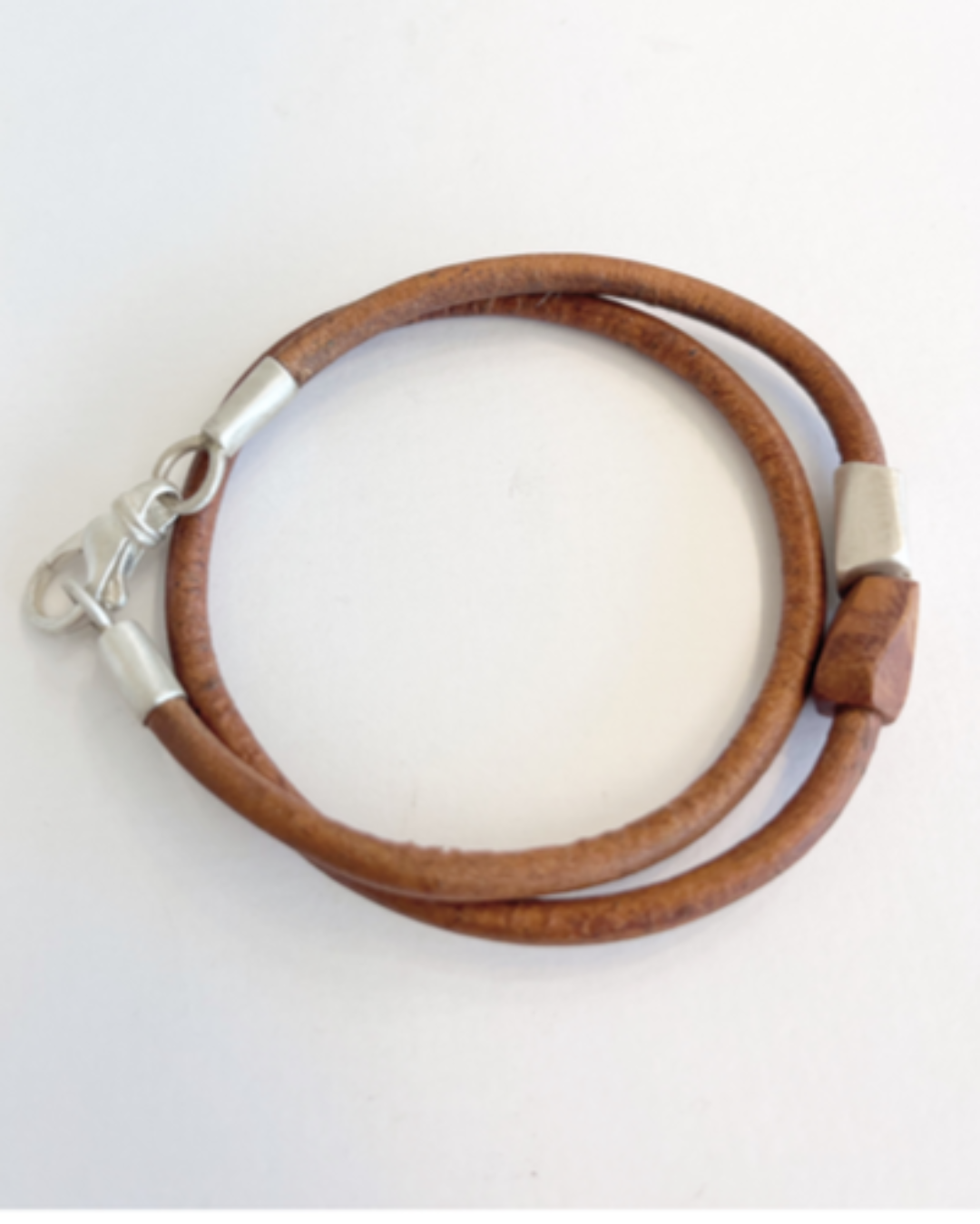 Brown double wrap leather bracelet with silver clasp on a white background