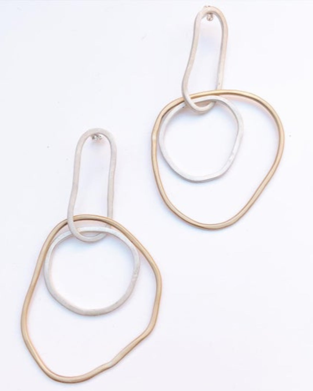 Pair of gold and silver hoop earrings on a white background