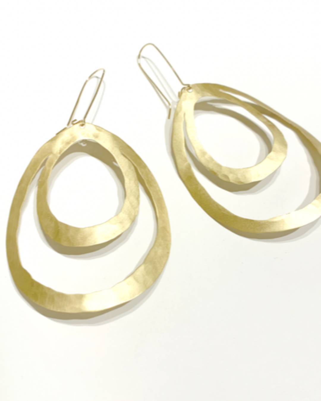 Gold teardrop hoop earrings on a white background
