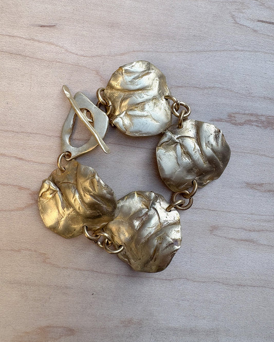 Bronze textured bracelet on a light wood surface