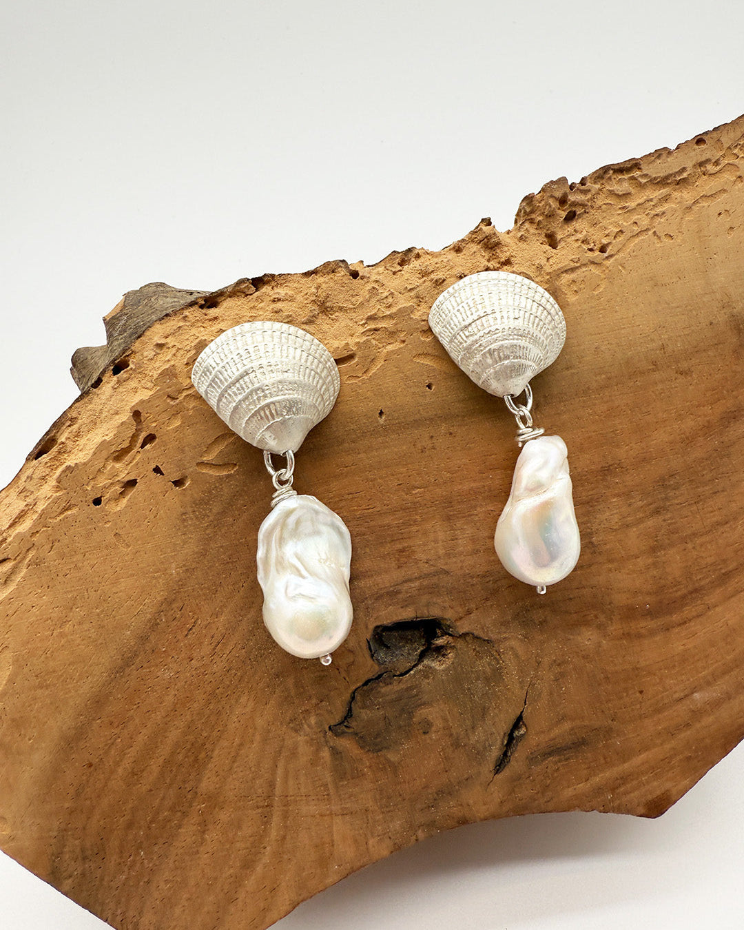Pair of pearl earrings on a wooden surface