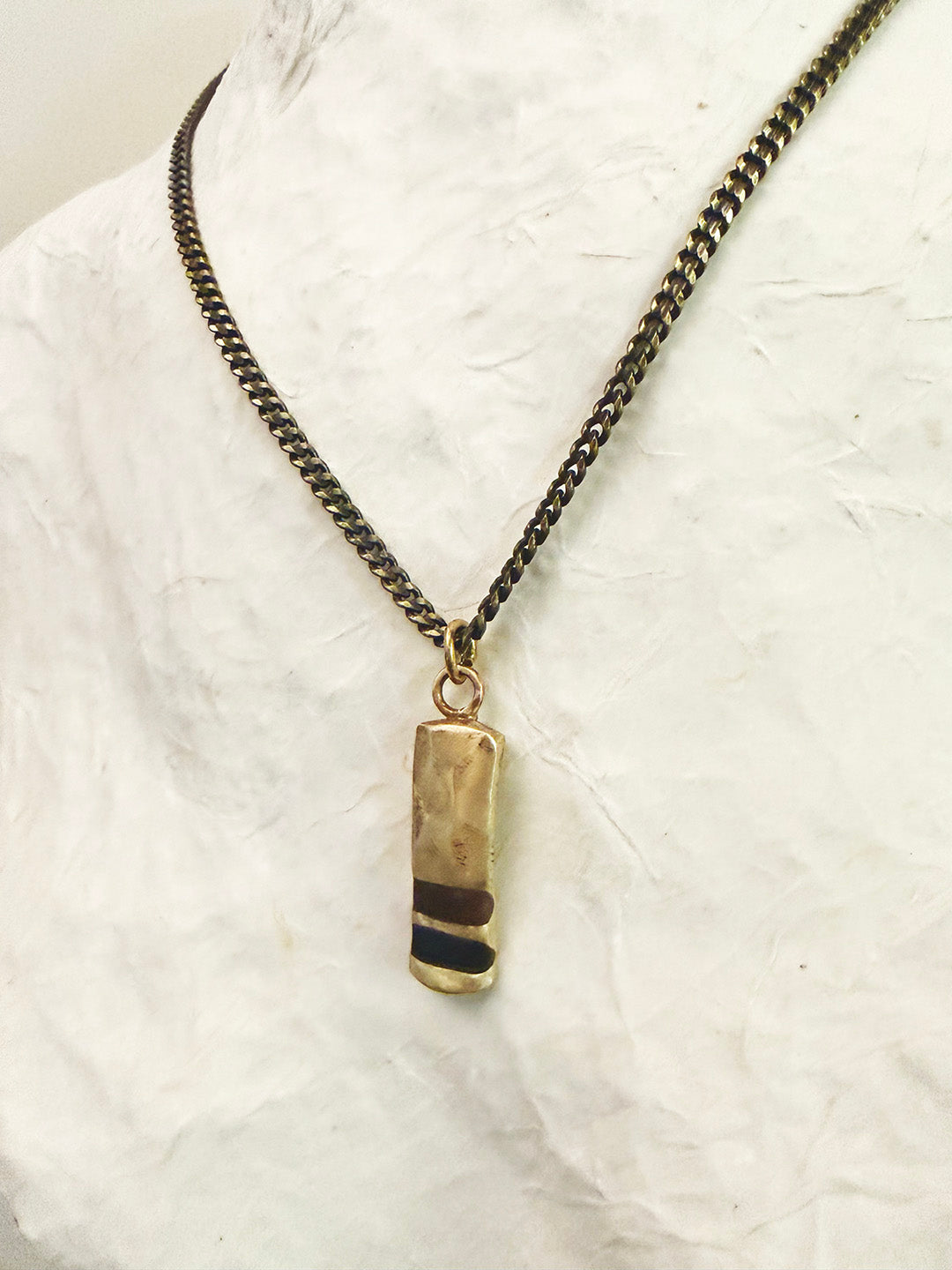 Necklace with a pendant on a textured white surface
