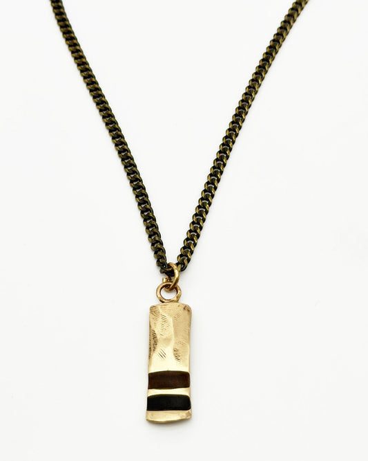 Necklace with a gold and black pendant on a white background