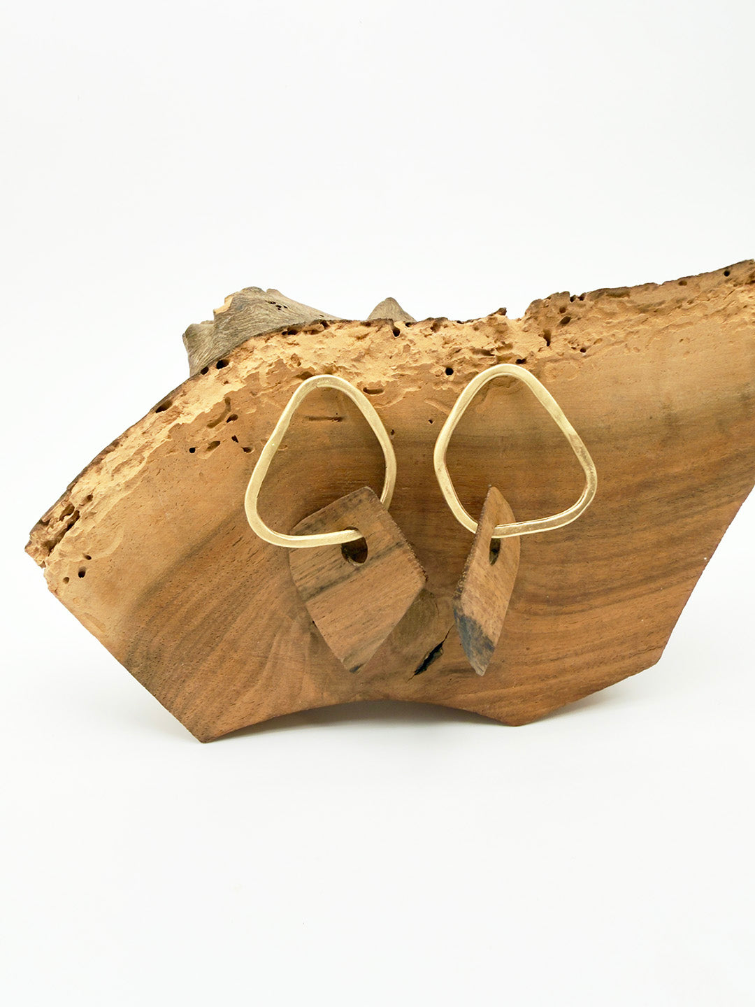 Gold hoop earrings on a wooden surface