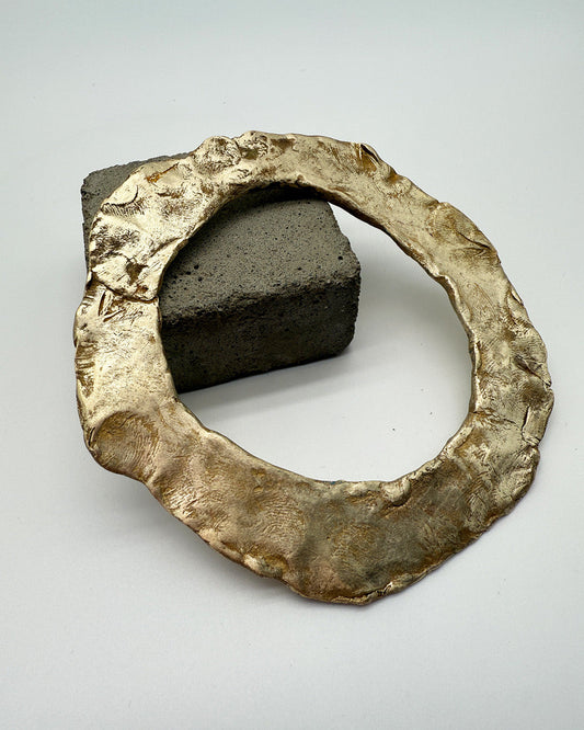 Bronze ring with a central stone on a light gray background