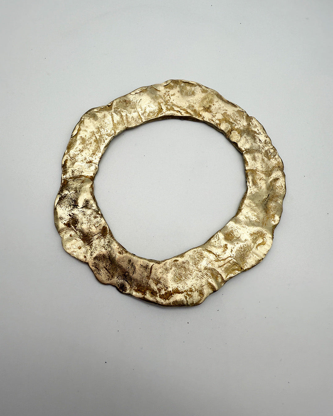 Gold ring with a textured surface on a gray background